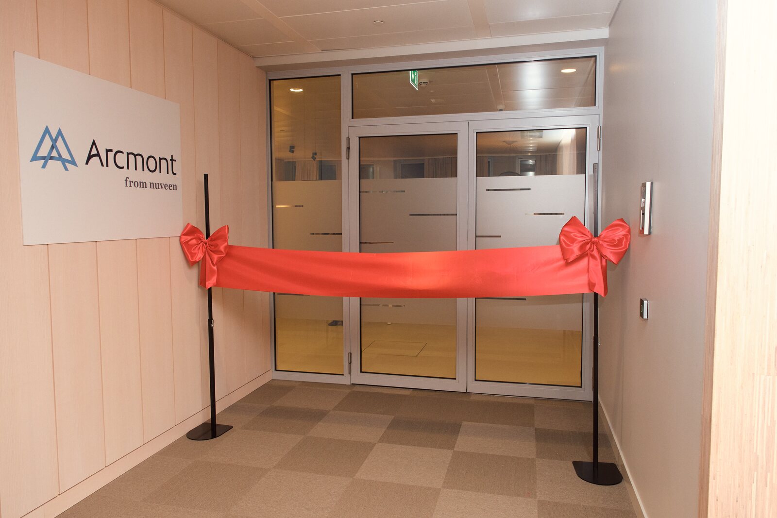 Arcmont — Arcmont logo and red ribbon at the office entrance
