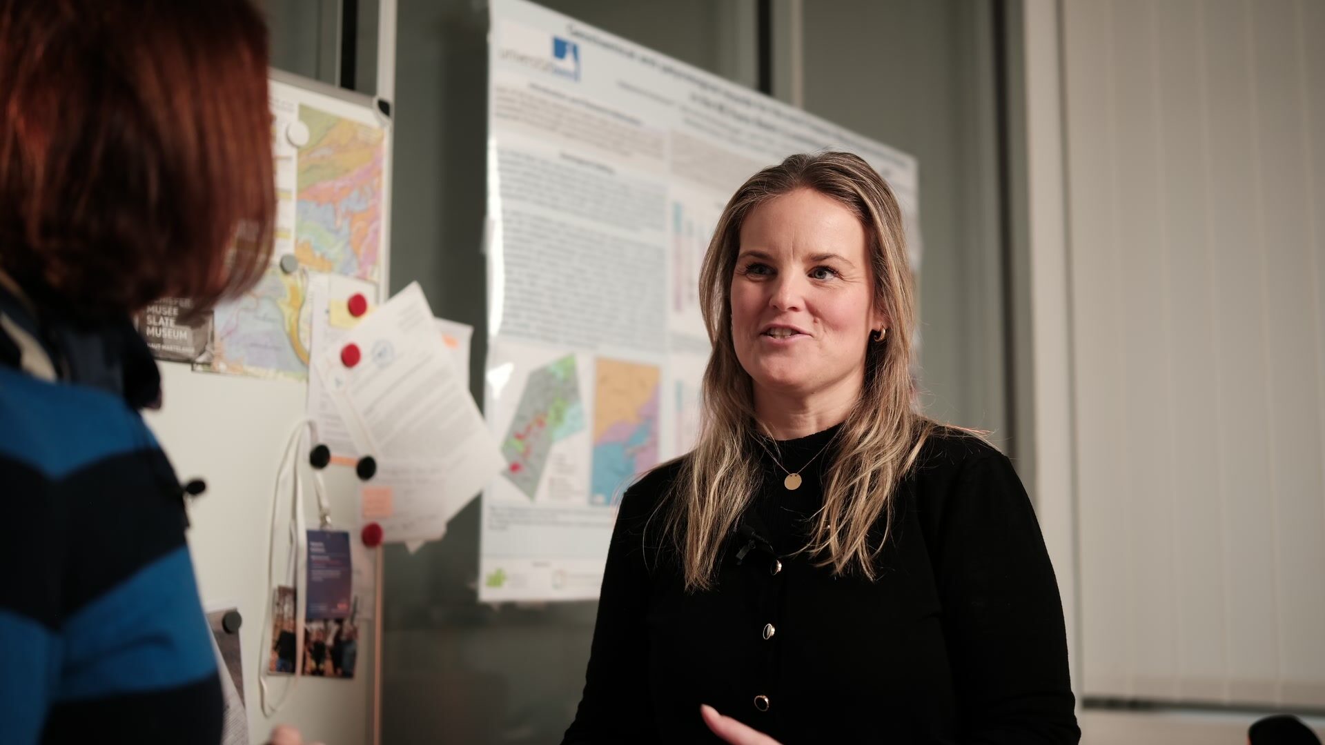 University of Luxembourg — Still from an interview film: filmed over the shoulder, poster wall behind